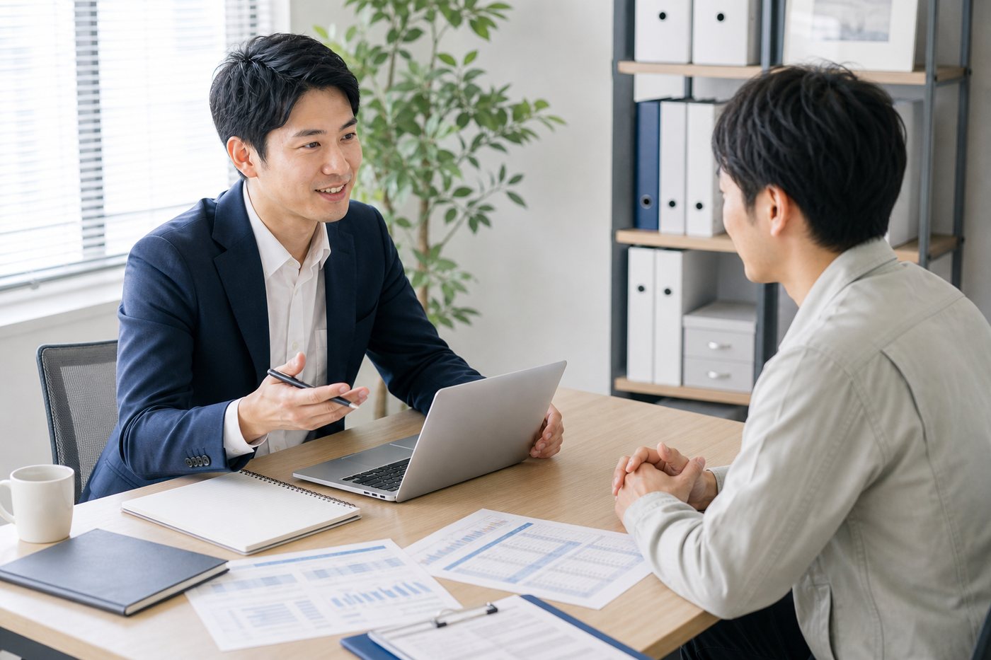 ノートPCと資料を見ながら初回相談をしている商談風景