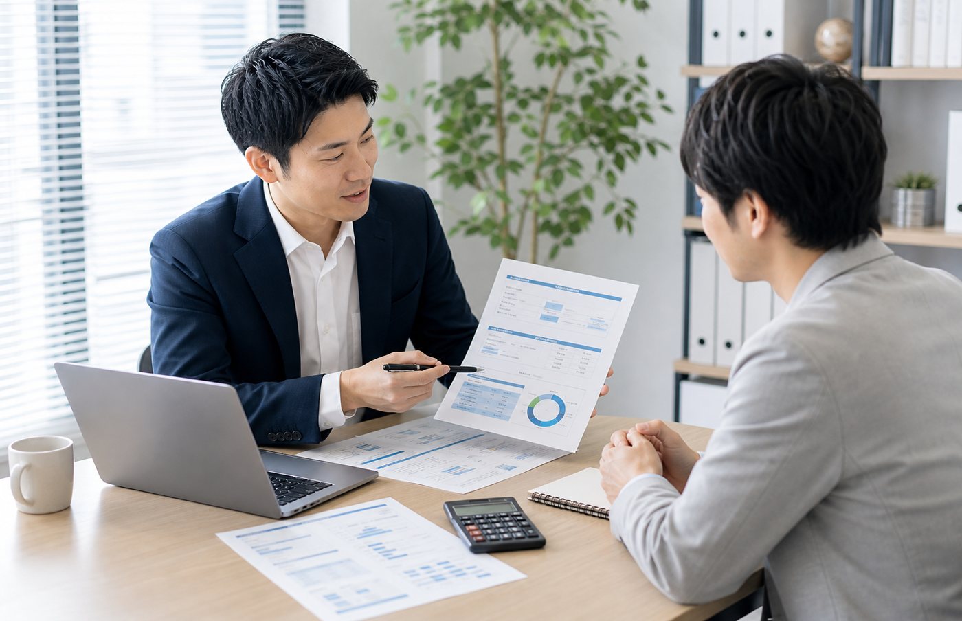 導入後の運用や改善提案について資料を見ながら相談している打ち合わせ風景